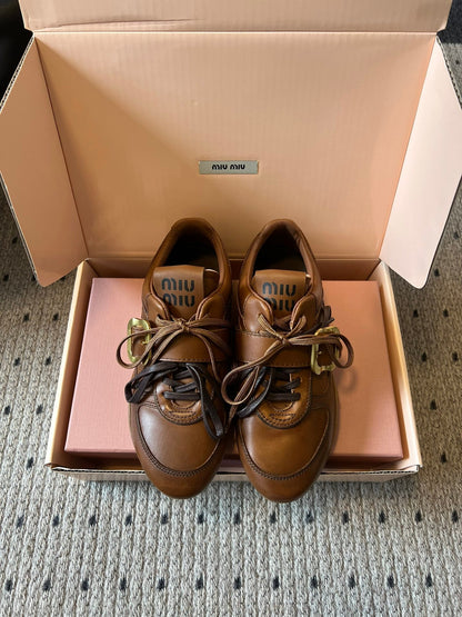 MIUMIU 26S GYMNASIUM SNEAKER IN COGNAC BROWN CALFSKIN WITH GOLD BUCKLED STRAP