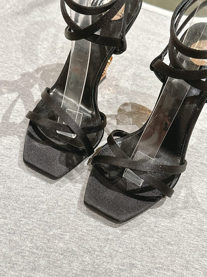 YSL 25S HIGH-HEEL SANDALS 100 MM IN BLACK SATIN WITH YSL LOGO HEEL DESIGN IN GOLD