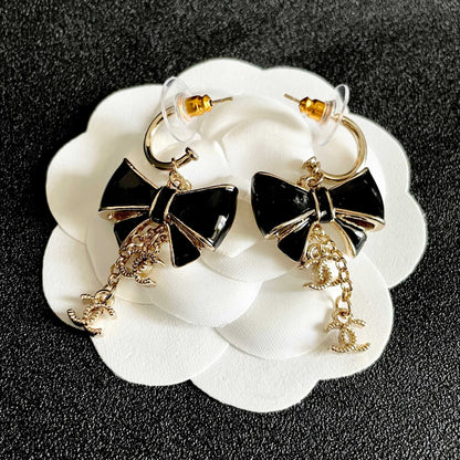 CHANEL 26S DOUBLE C LOGO BLACK ENAMEL BOW DANGLE EARRINGS WITH CHAIN CHARMS IN GOLD METAL 629178