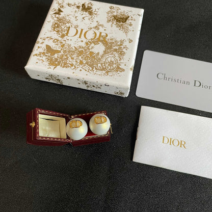 CD 26S RESIN PEARL LOGO STUD EARRINGS IN GOLD TONE METAL 630807