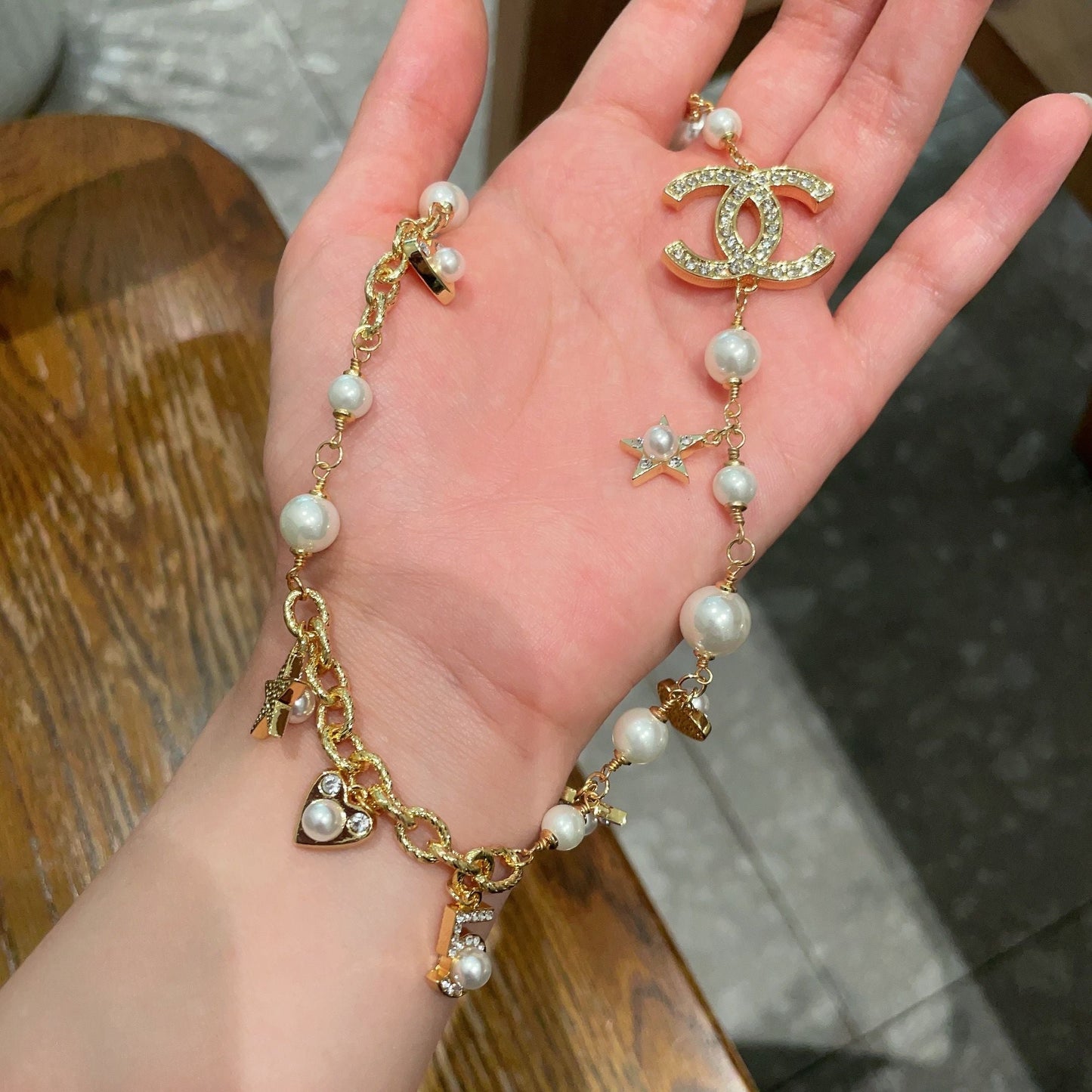 CHANEL 26S DOUBLE C LOGO PEARL CHARM NECKLACE WITH STAR AND HEART DETAILS IN GOLD METAL 631895