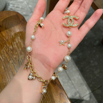 CHANEL 26S DOUBLE C LOGO PEARL CHARM NECKLACE WITH STAR AND HEART DETAILS IN GOLD METAL 631895
