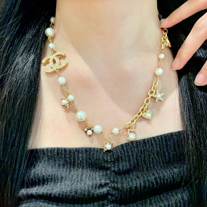 CHANEL 26S DOUBLE C LOGO PEARL CHARM NECKLACE WITH STAR AND HEART DETAILS IN GOLD METAL 631895