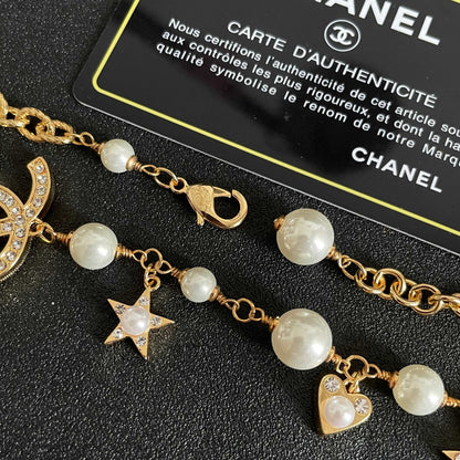 CHANEL 26S DOUBLE C LOGO PEARL CHARM NECKLACE WITH STAR AND HEART DETAILS IN GOLD METAL 631895