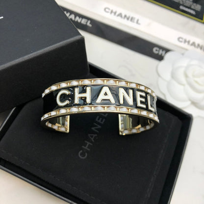 CHANEL 26S CHANEL LOGO BLACK ENAMEL STATEMENT CUFF BRACELET IN GOLD METAL 630834