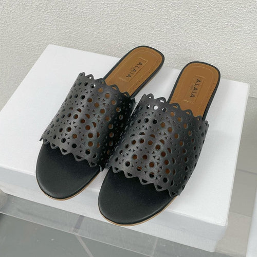ALAIA VIENNE FLAT MULES IN BLACK LAMBSKIN