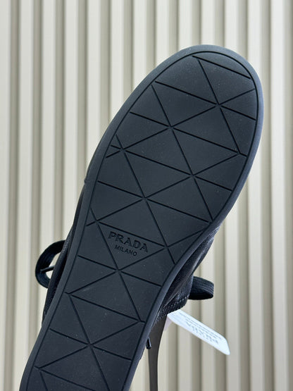 PRADA 25S COLLAPSE MULES IN BLACK CALFSKIN