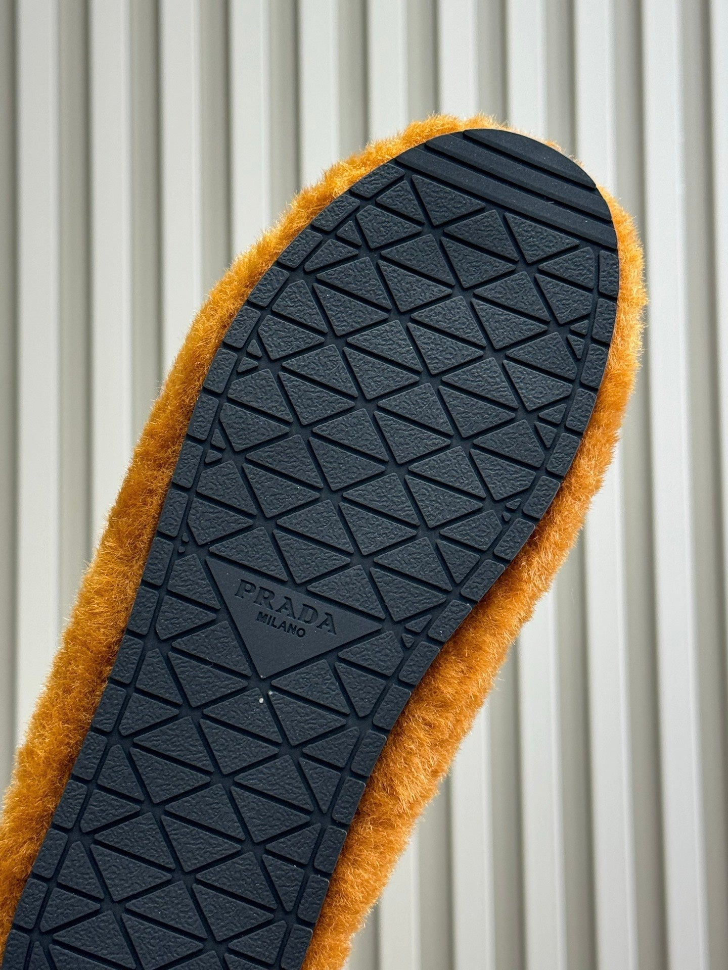PRADA 25S CLOGS IN DARK ORANGE SHEARLING